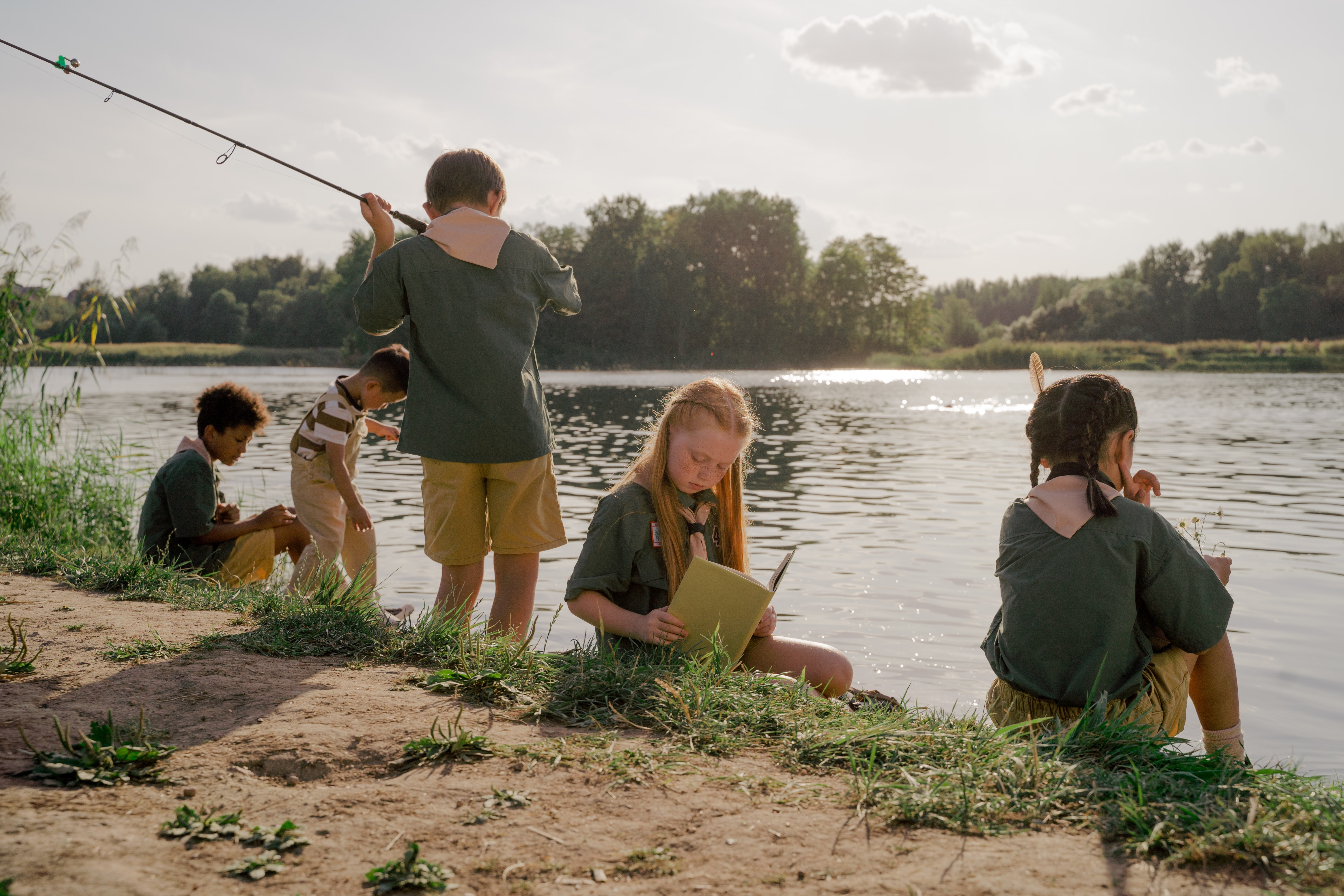 a group of children fishing by a river
